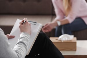 man hand writing in front of a woman therapy and counseling venice