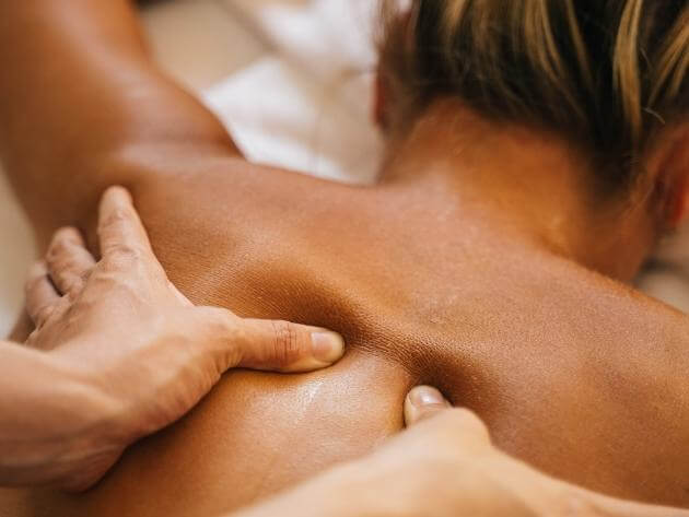 masseur doing deep tissue massage to a female client in venice