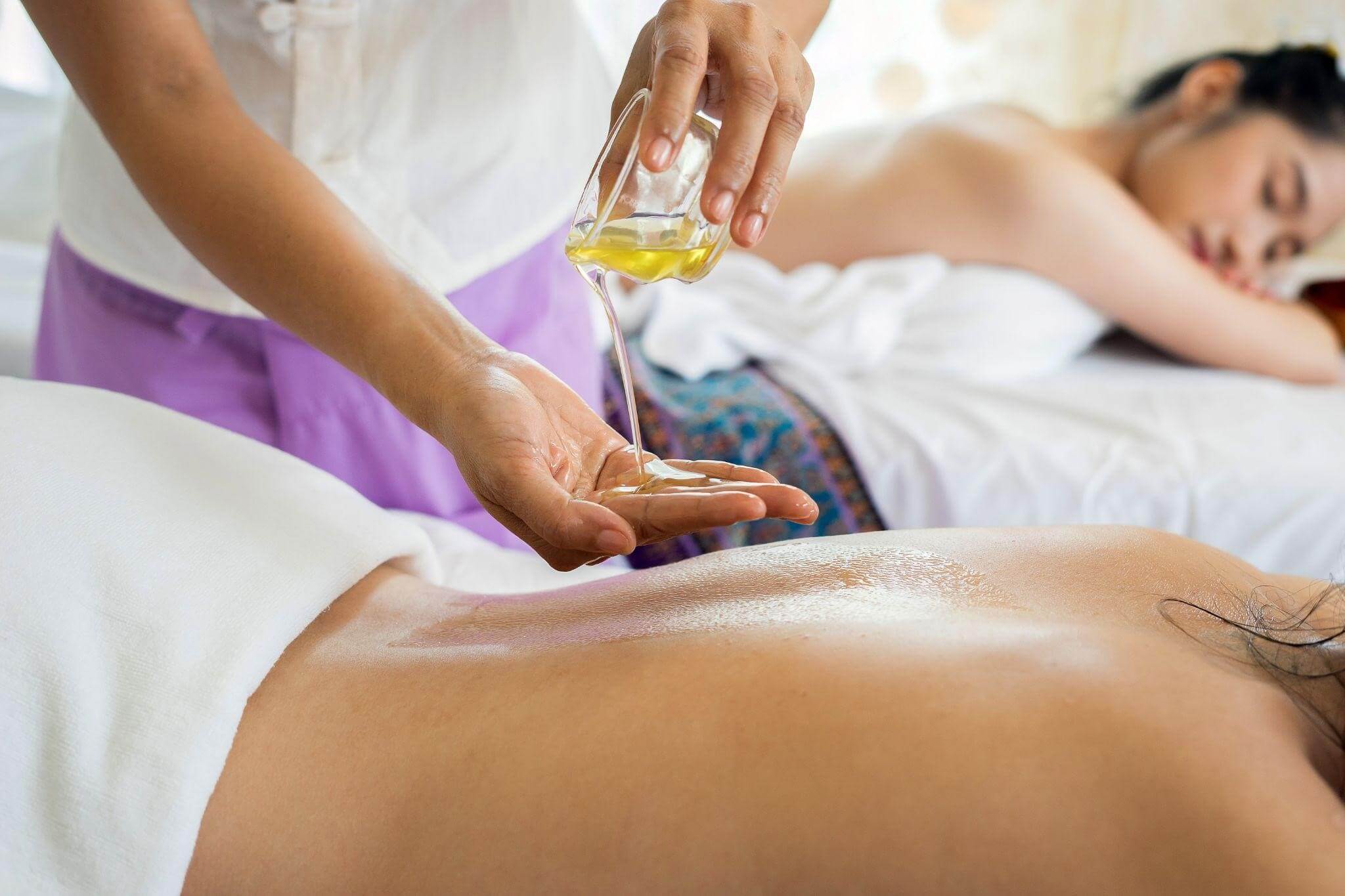 masseur puting na essential oil to a client massage therapy in venice