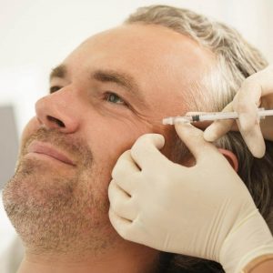 professional doing botox injection to a male client in venice