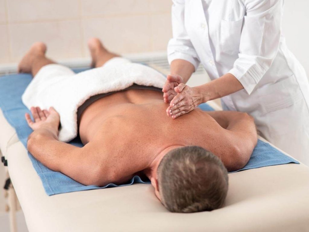 masseur performs deep tissue massage to a male client venice